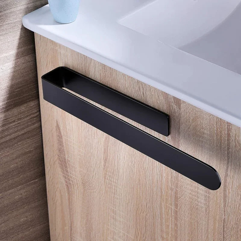 Black adhesive towel ring on wooden cabinet.