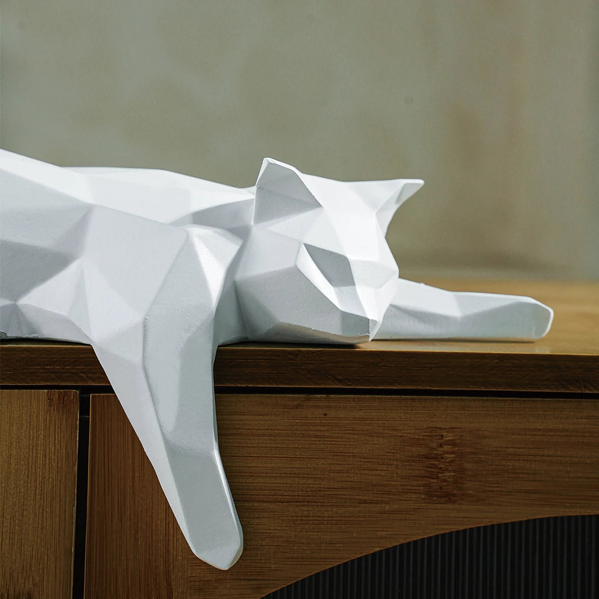 Side view of white geometric decor cat resting on furniture.