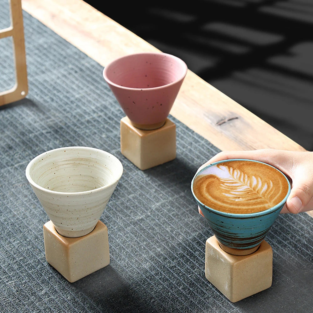 Three ceramic coffee cups on wooden stands