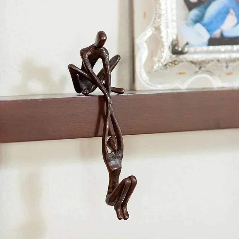 Wall-mounted sculpture ornament showing one figure pulling another.