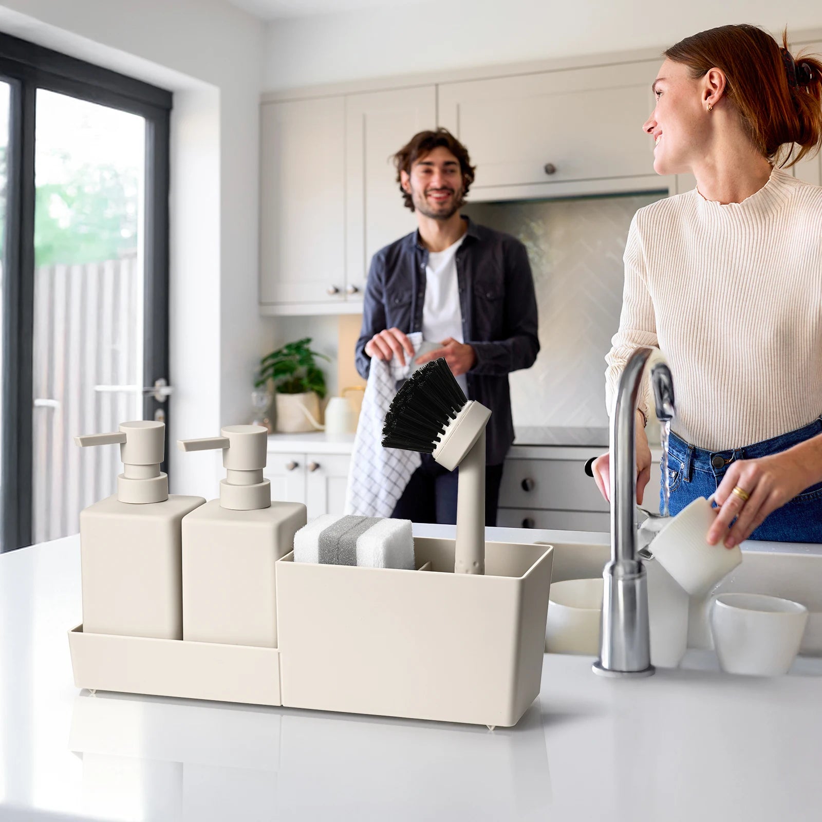 Couple doing dishes in modern kitchen with beige kitchen soap dispenser set on counter.