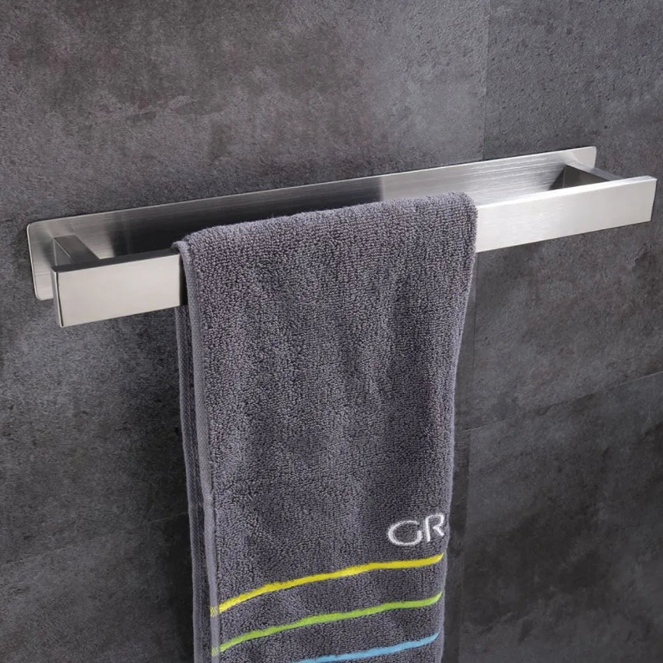 Stainless steel self adhesive towel rail holding a gray towel.