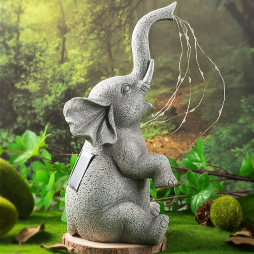 Cute elephant statues sitting on moss with glowing trunk lights.