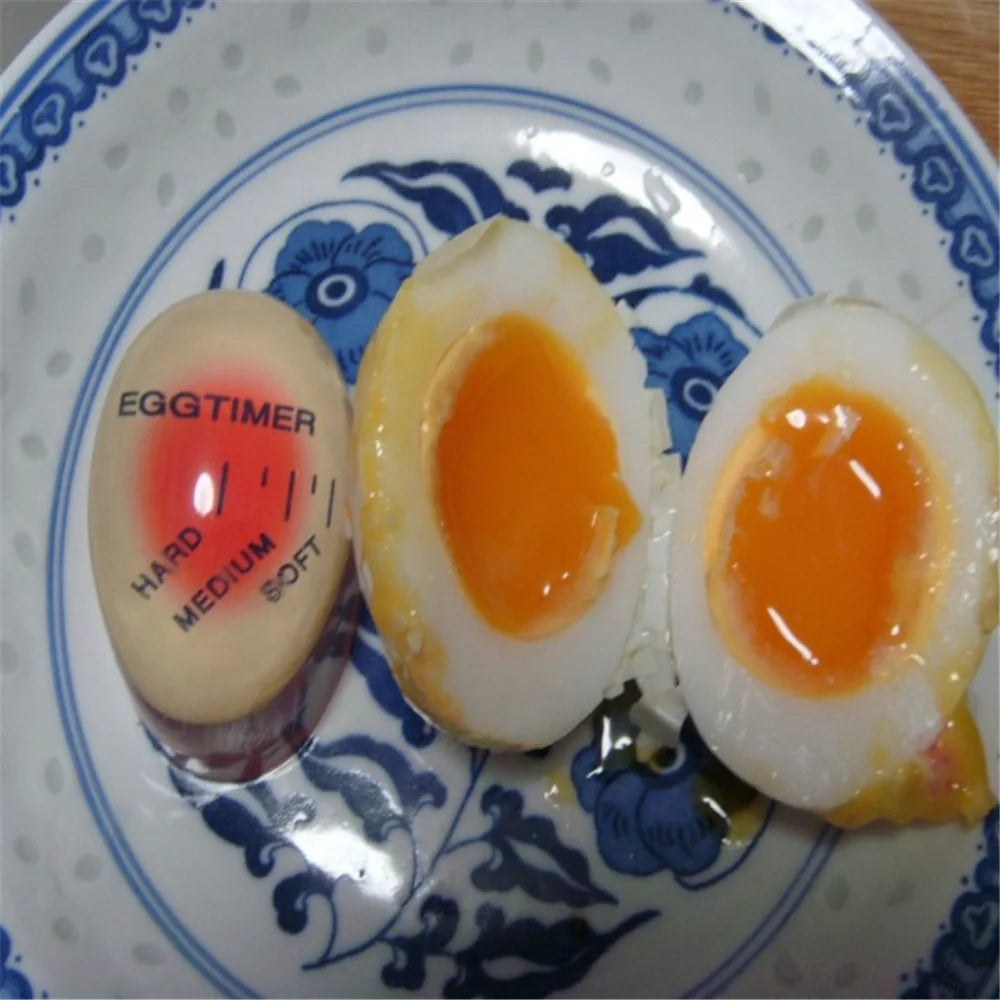 Egg timer and medium-soft boiled eggs on a plate.