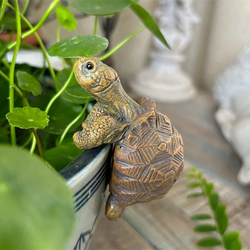 Garden sculpture of a turtle perched on a white wooden stand next to a plant.