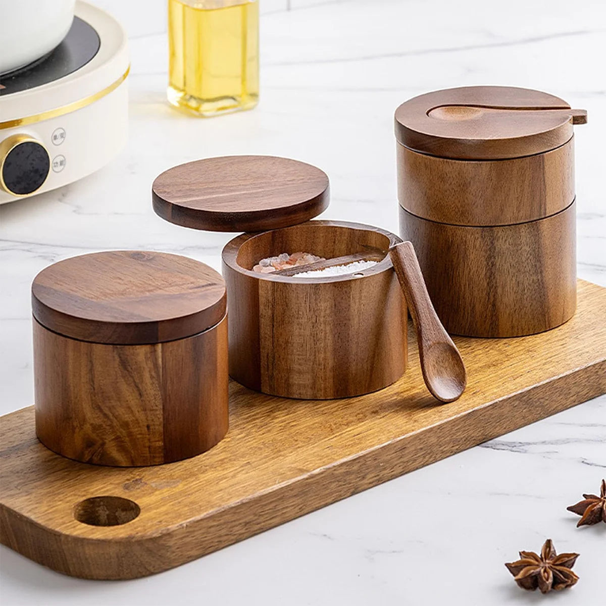 Set of three wooden salt cellar with lid on a tray.