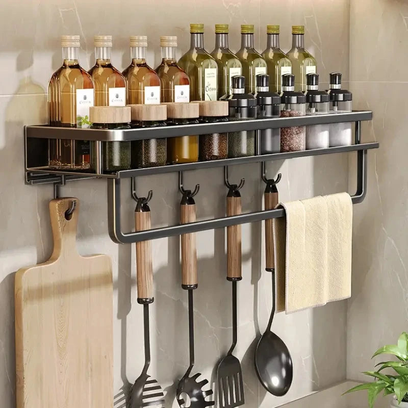 Kitchen spice rack organizer with seasoning bottles, jars, utensils, and towel bar.