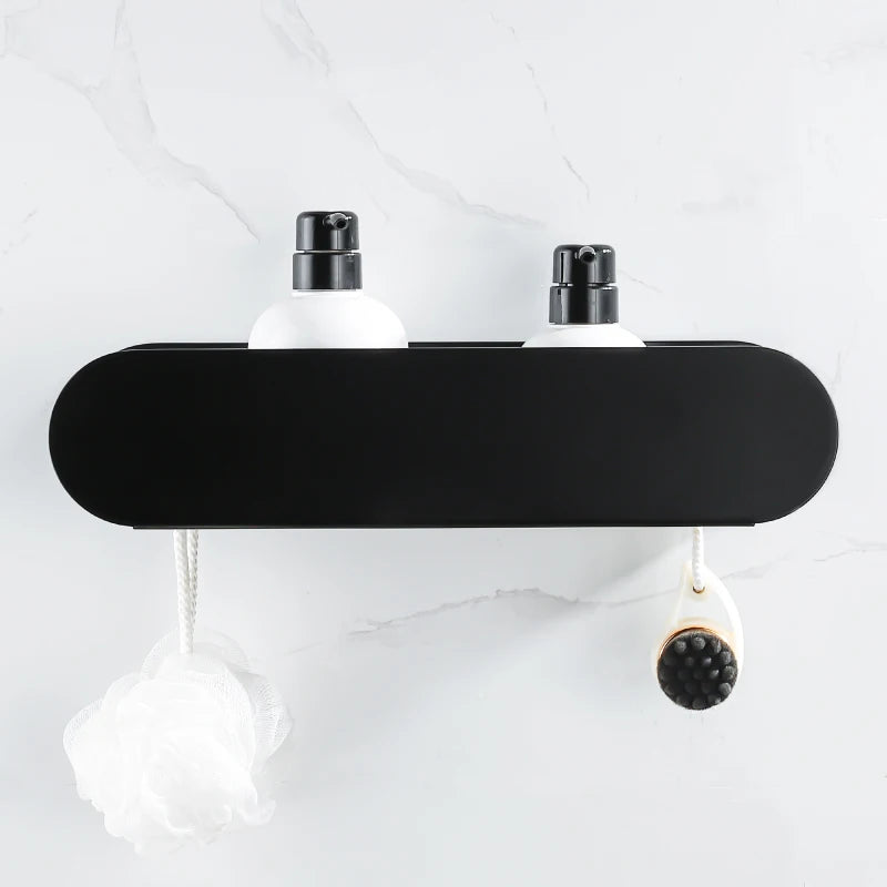 Black bathroom shelf organizer mounted on wall, holding two bottles and hanging bath accessories