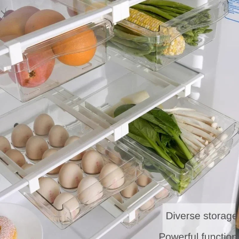 Refrigerator drawers filled with eggs, oranges, and fresh green vegetables.