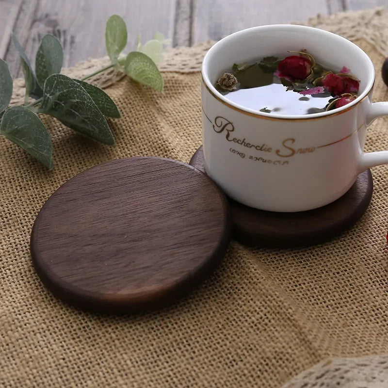 Dark square coaster under a cup, set on a burlap cloth – wooden coaster.