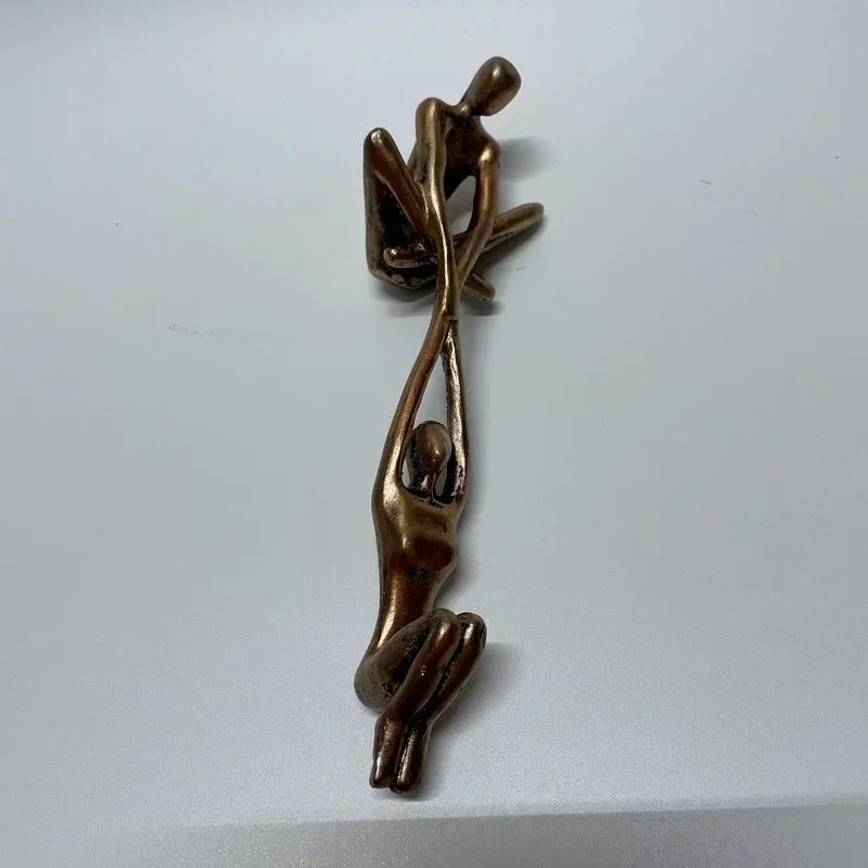 Bronze sculpture ornament showing climbing figures from top view.