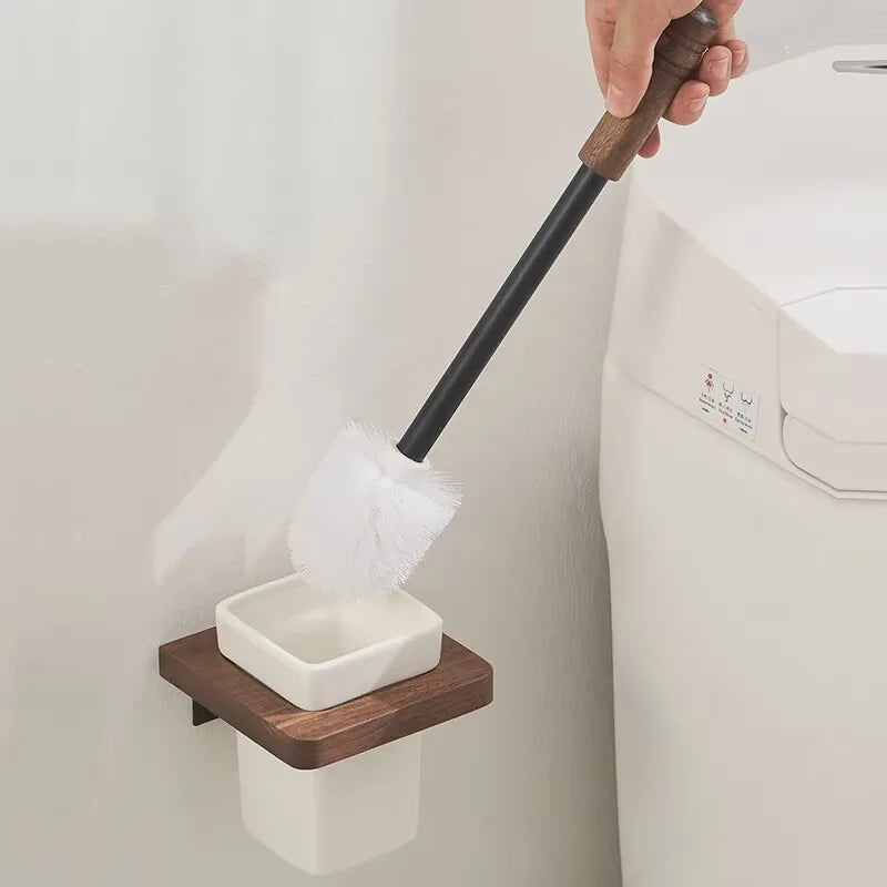A wall-mounted wooden toilet brush holder with a white ceramic insert