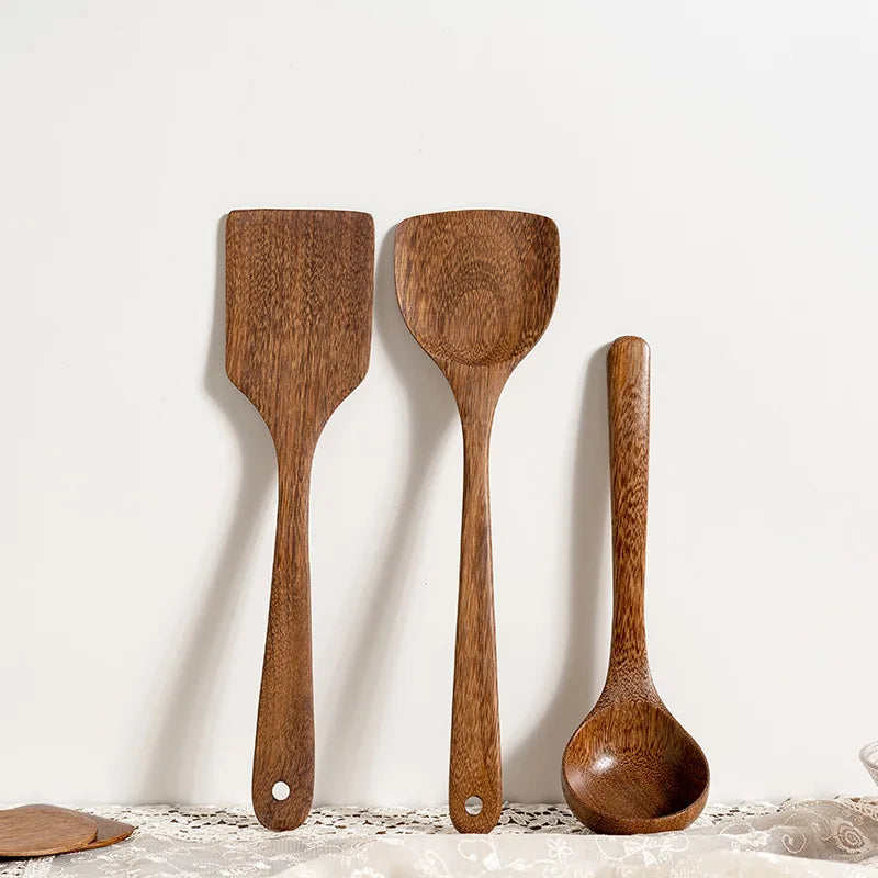 Three wooden kitchen utensils—spatula, ladle, and scoop—on a white background.