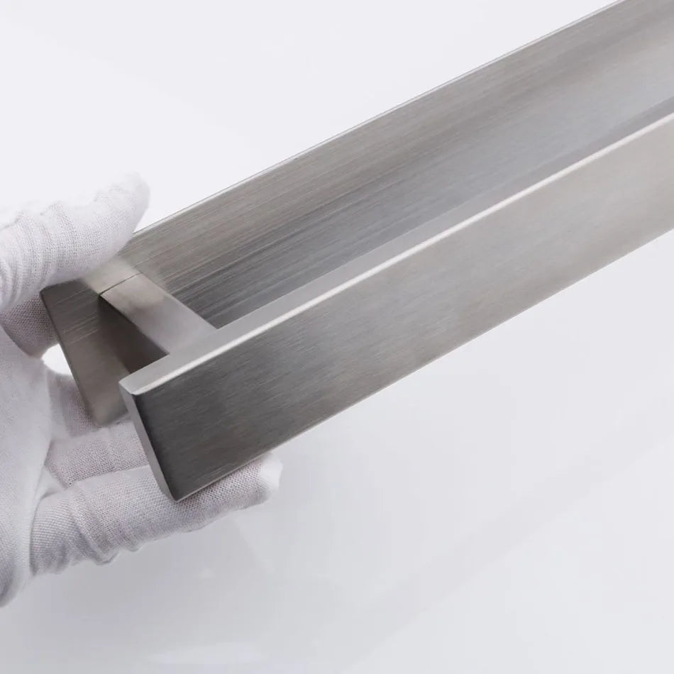 Close-up of stainless steel self adhesive towel rail being held with gloved hands.