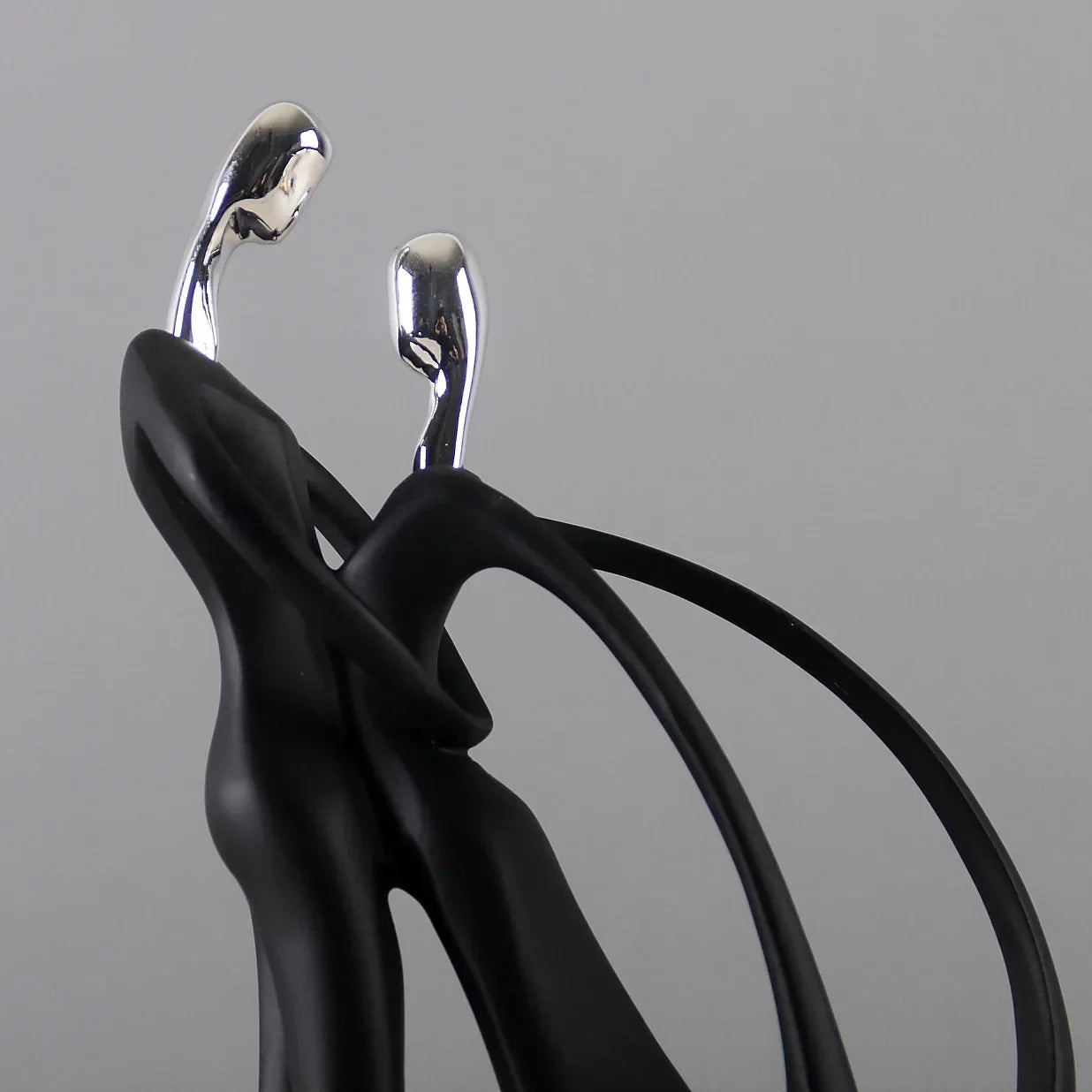 Black dancing figurine, two intertwined figures.