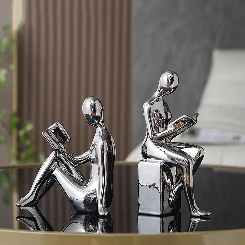 Silver and gold bookshelf stopper figures displayed side by side.
