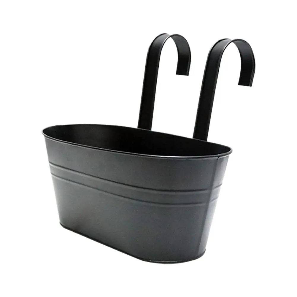 Side view of a single black hanging flower pot with handle.

