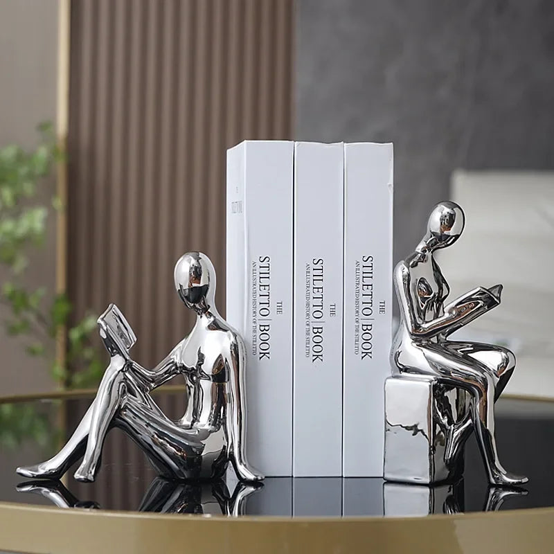 Silver bookshelf stopper set with reading figures holding up books.