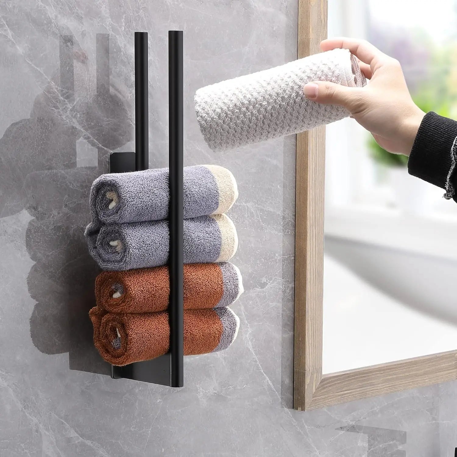 Vertical adhesive towel bar on a wall with rolled towels stacked between the bars.