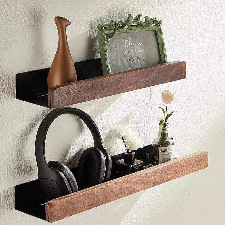 Two floating wood shelves decorated with a vase, picture frame, and headphones.