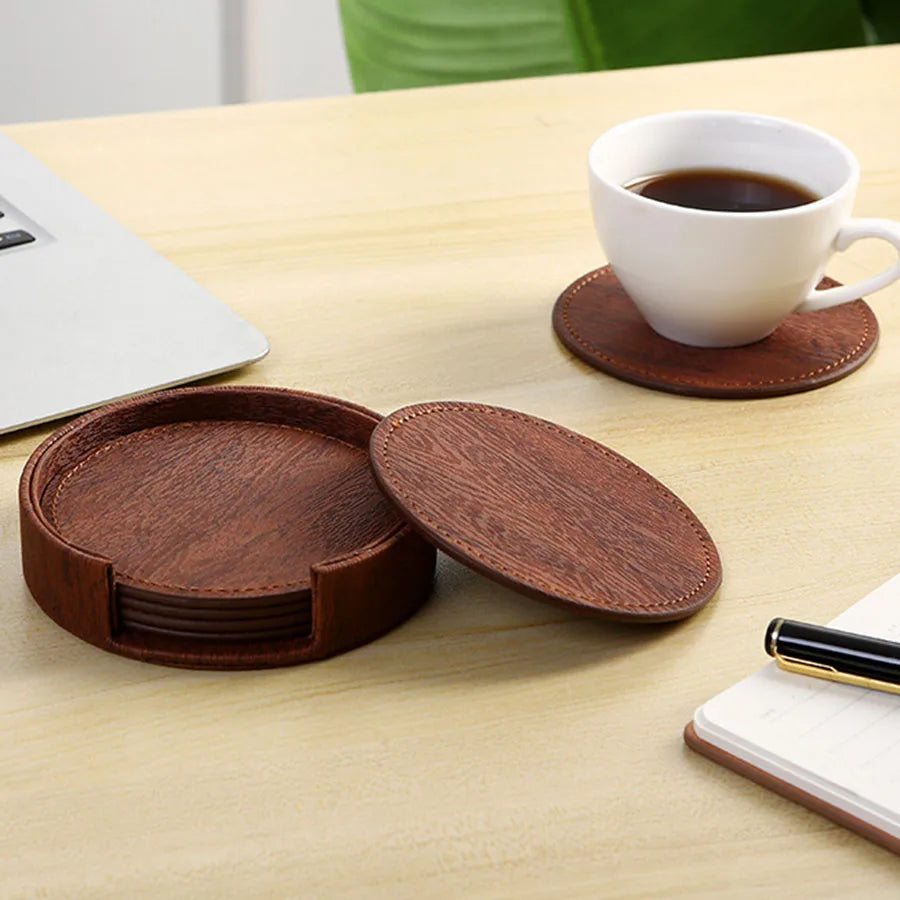 Brown coasters tea with a cup and holder on desk.