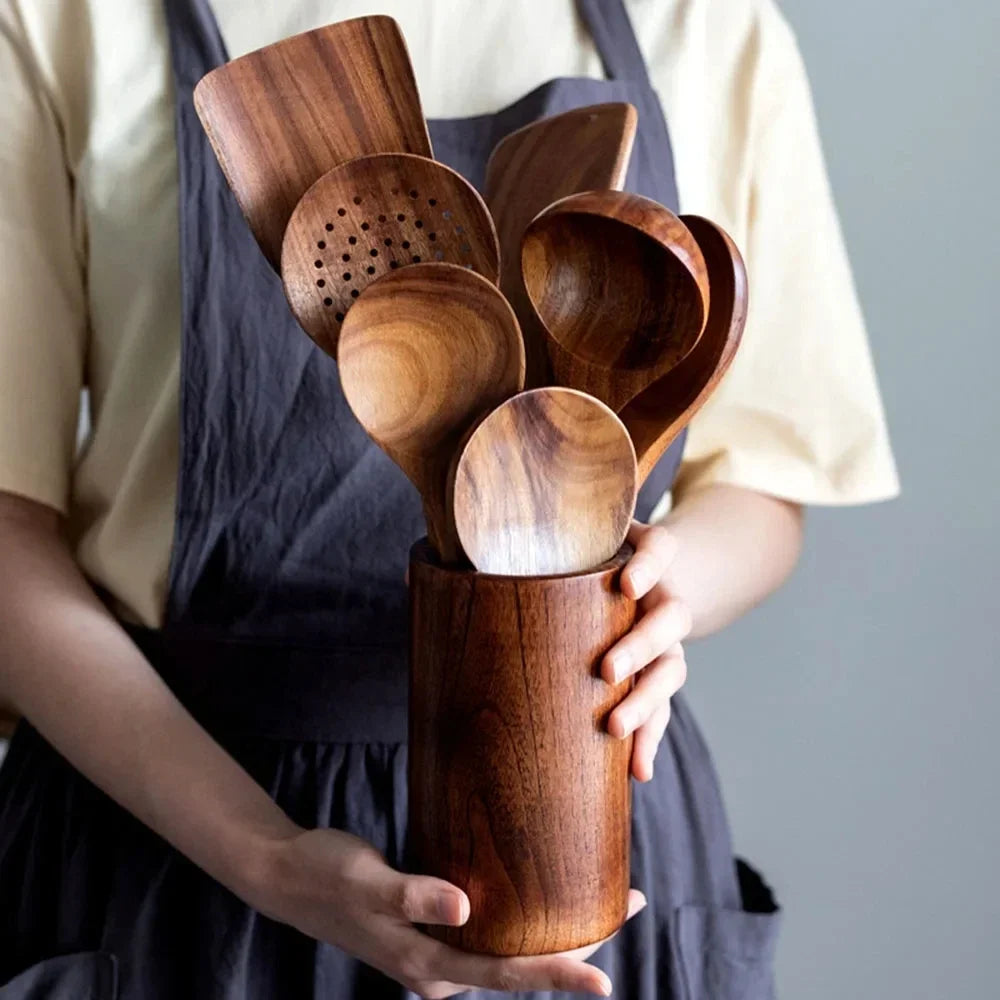 Wooden kitchenware set in jars with kitchen decor.