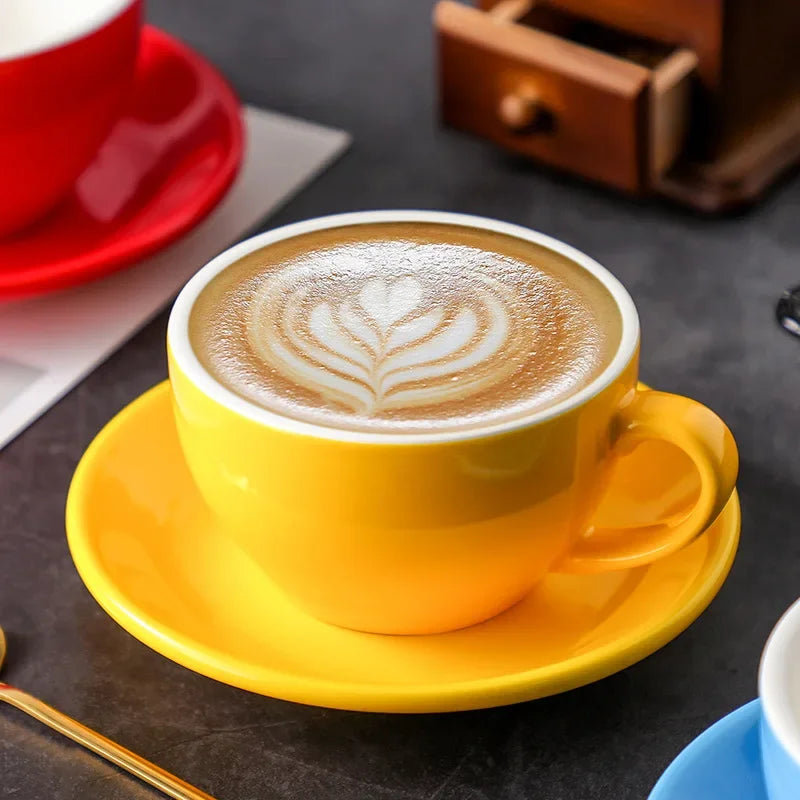 Yellow ceramic mug with latte art on a saucer.