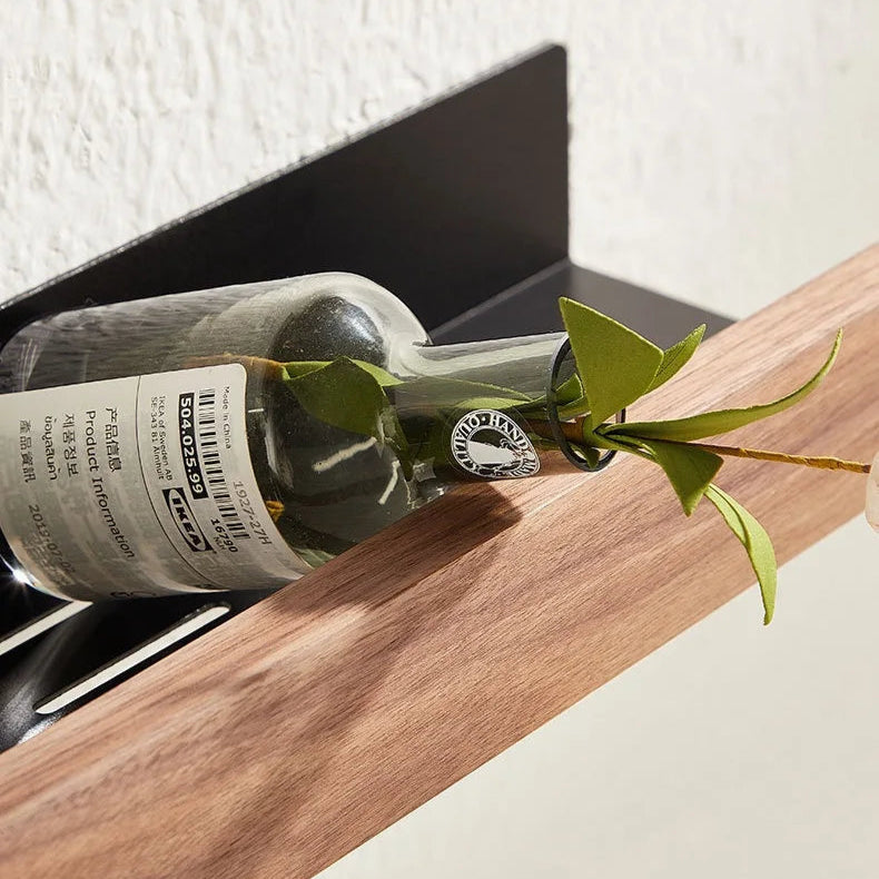 A floating wood shelf holding a wine bottle, seen from the side.