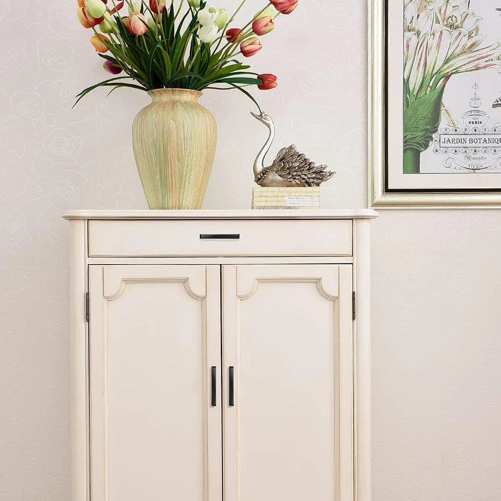 White cabinet with decorative kitchen cabinet knobs and a vase on top.