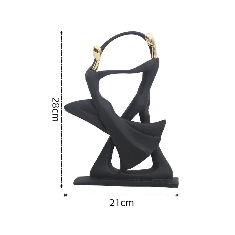 A golden dancing figurine of two abstract figures
