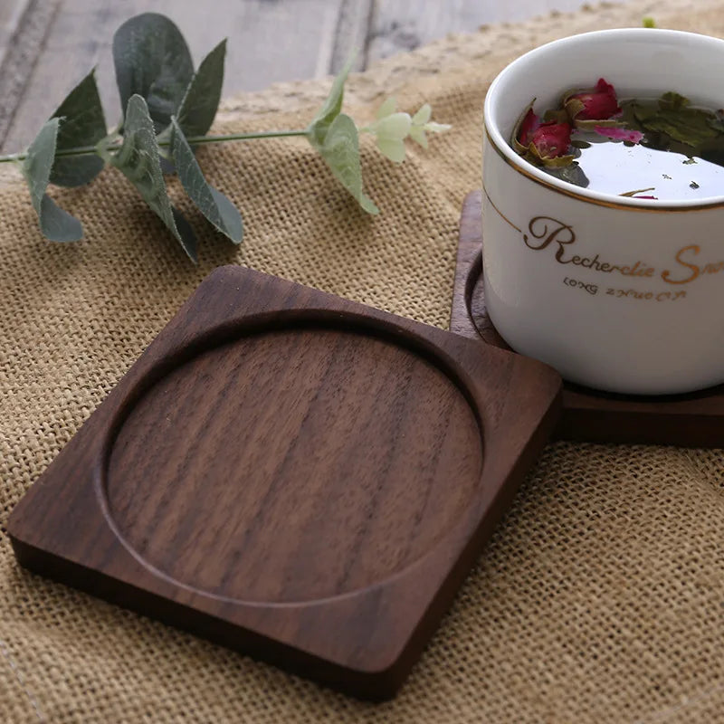 Square wooden coaster with a recessed round center holding a cup on a rustic table.