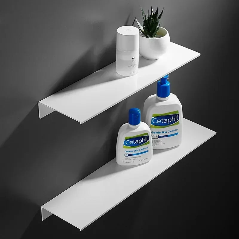 Two-tier white floating wall shelves holding hygiene products in bathroom.