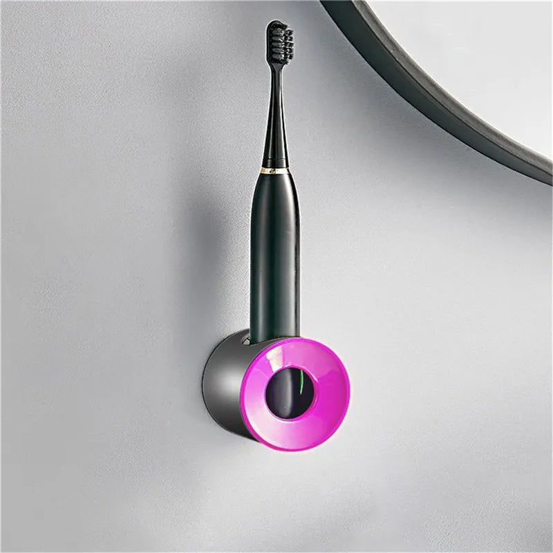 Toothbrush holder with pink circular top mounted on wall holding toothbrush